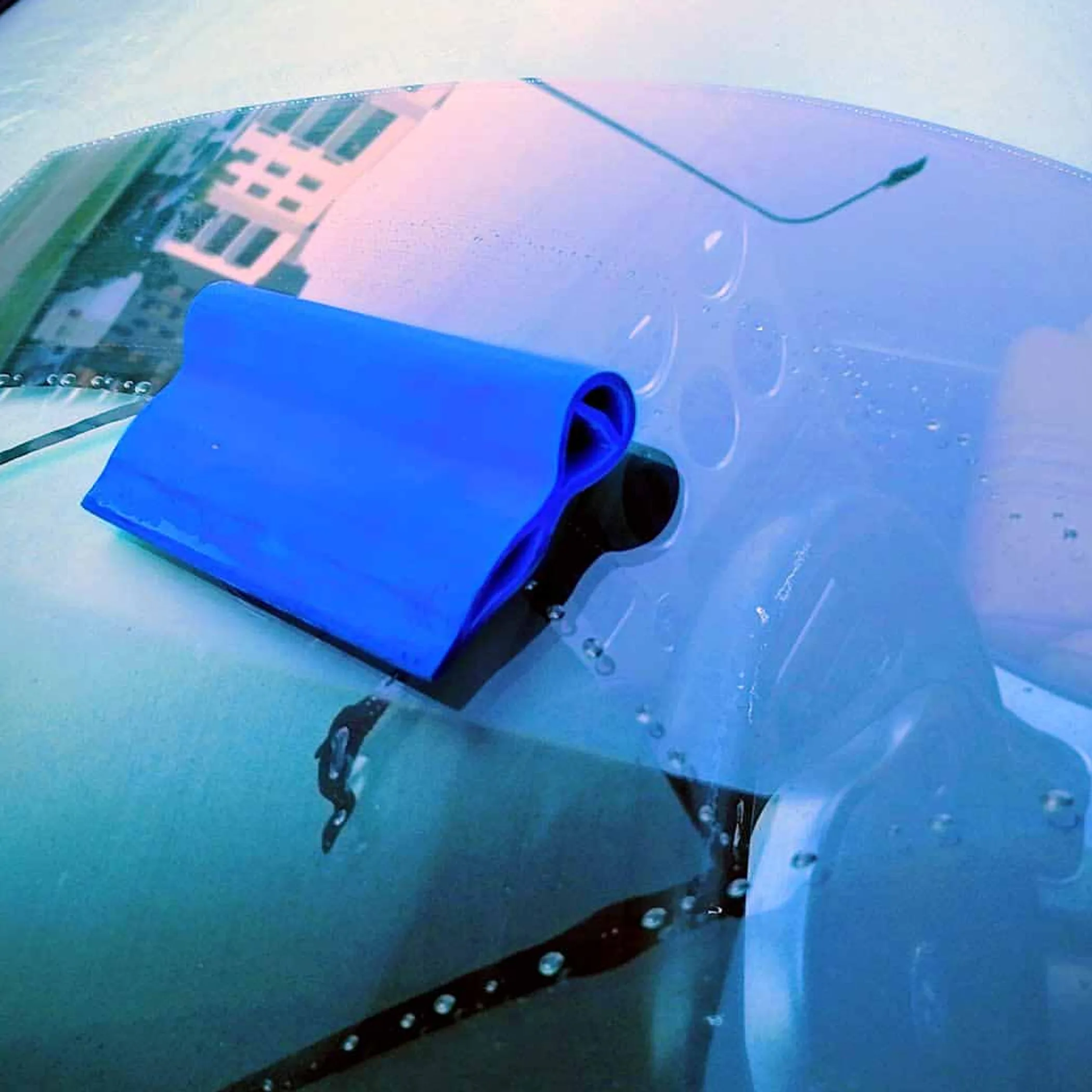 squeegee removing water from car surface